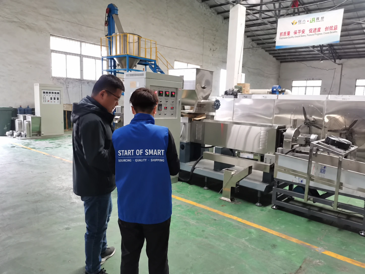 Anna and a supplier reviewing machinery in a Chinese factory